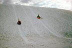Boys saucering down dunes