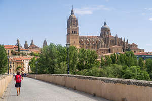 Lolo walking across the Roman Bridge towards the Salamanca Cathedral